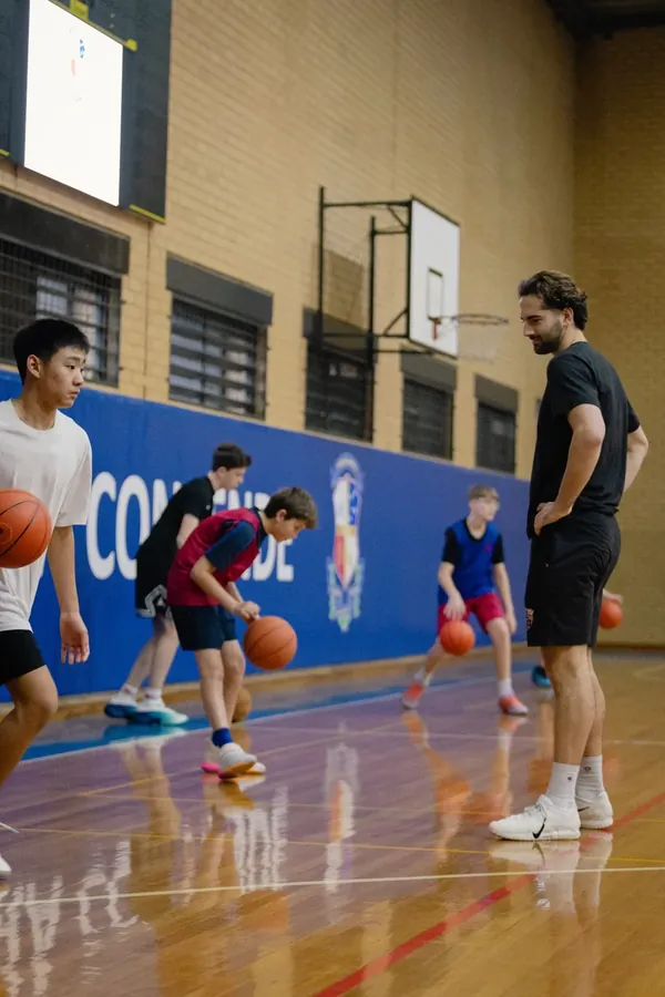 Players running dribbling drills while a coach watches